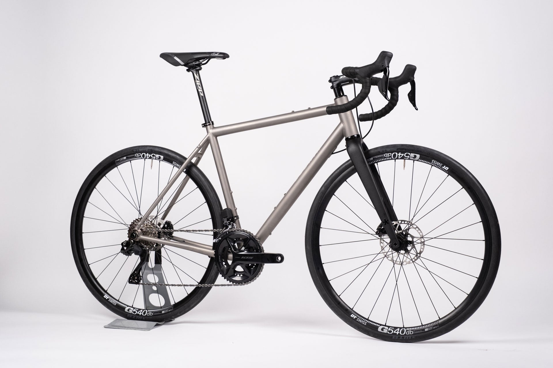 A titanium all-road bicycle with Shimano 105 Di2 groupset and DT Swiss Alloy Wheelset, equipped with Zipp Service Course handlebars and a Selle Italia X1 saddle.