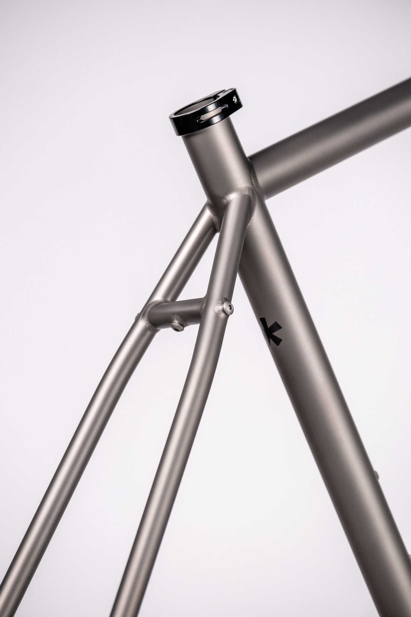 Close-up of a  titanium  bicycle frame with a white background