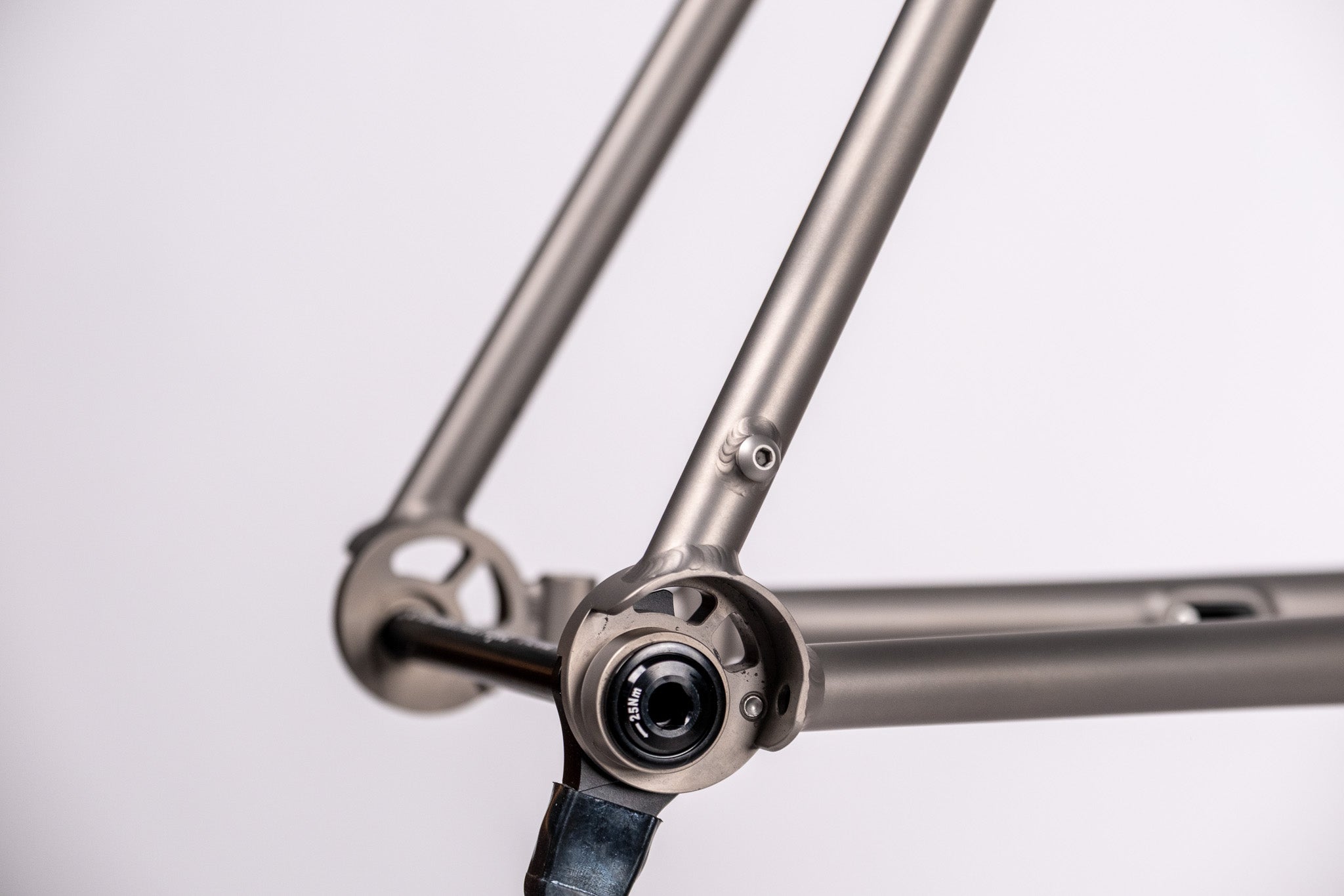 Close-up of a  titanium  bicycle frame with a white background
