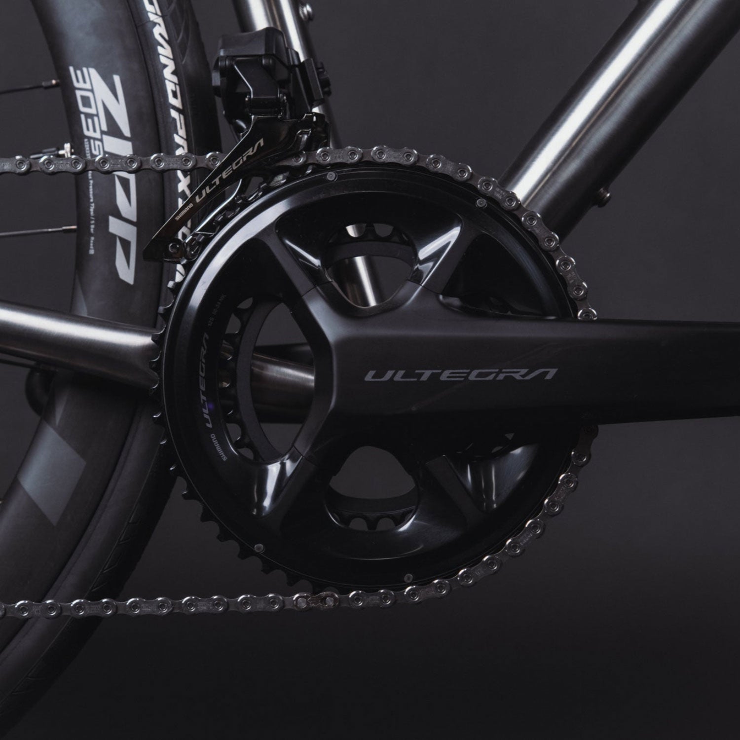 Close-up of a bicycle chain and gear system with 'Ultegra' branding on a dark background.