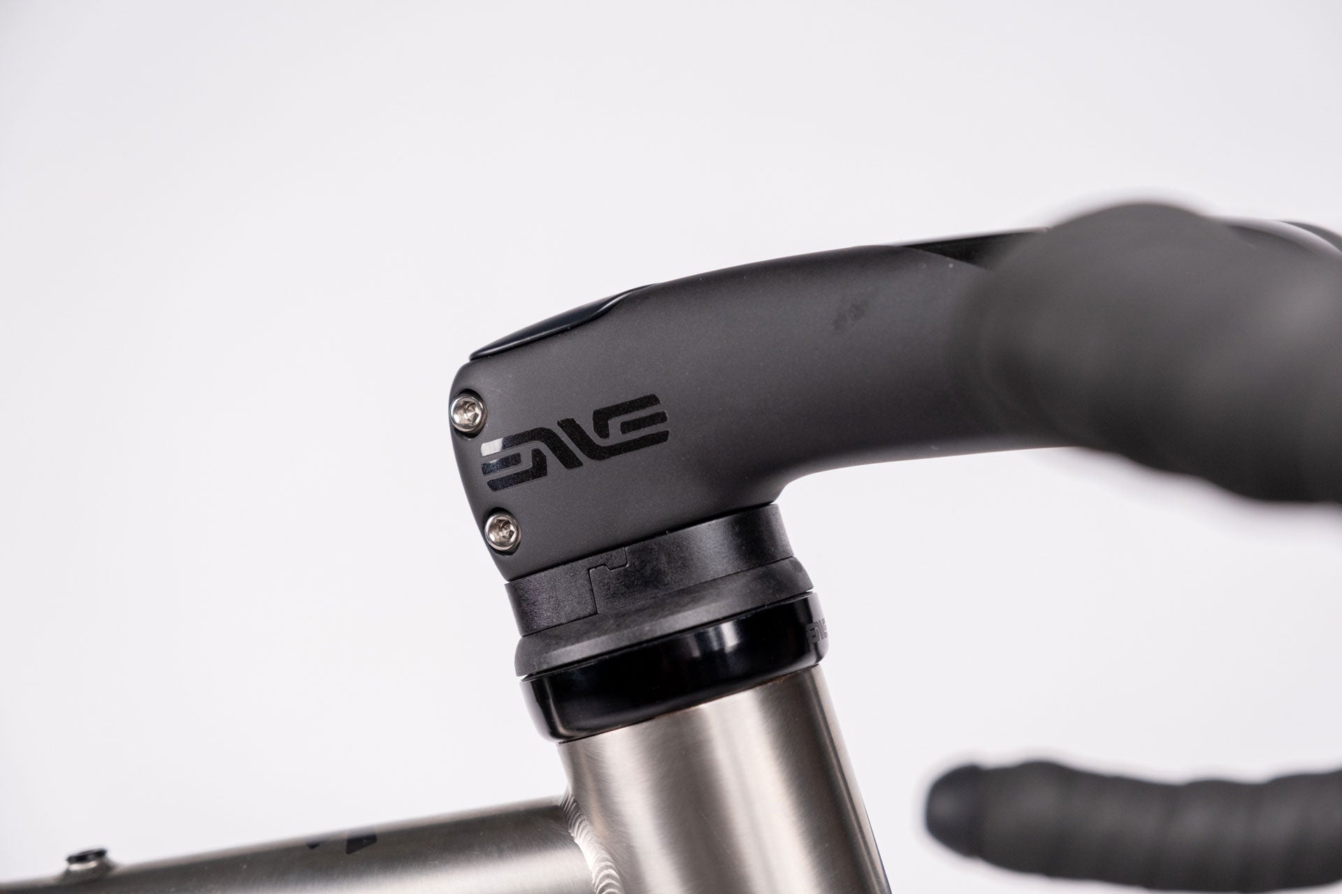 Close-up of a bicycle handlebar with a black grip and visible brand logo on a white background