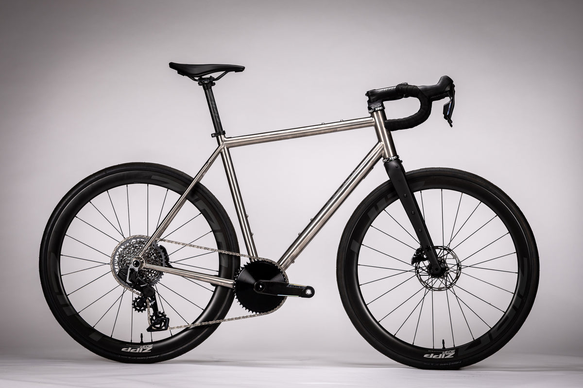 Gloria All Road titanium bicycle with a raw metal frame, drop handlebars and deep-section wheels