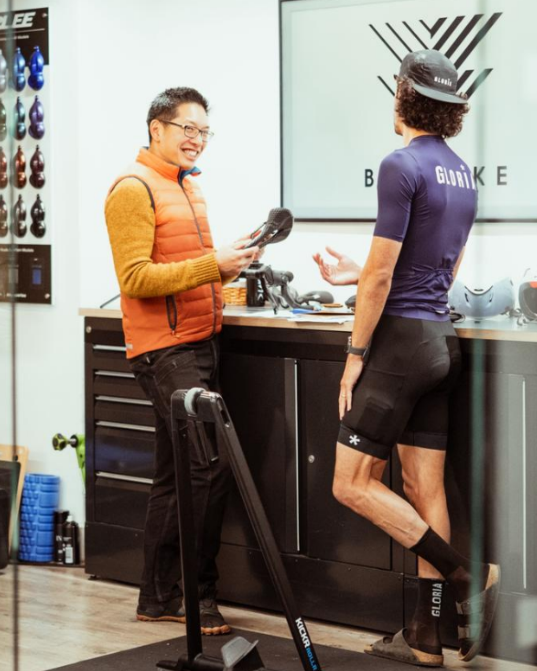 Two people in a bike fitting room talking about saddles