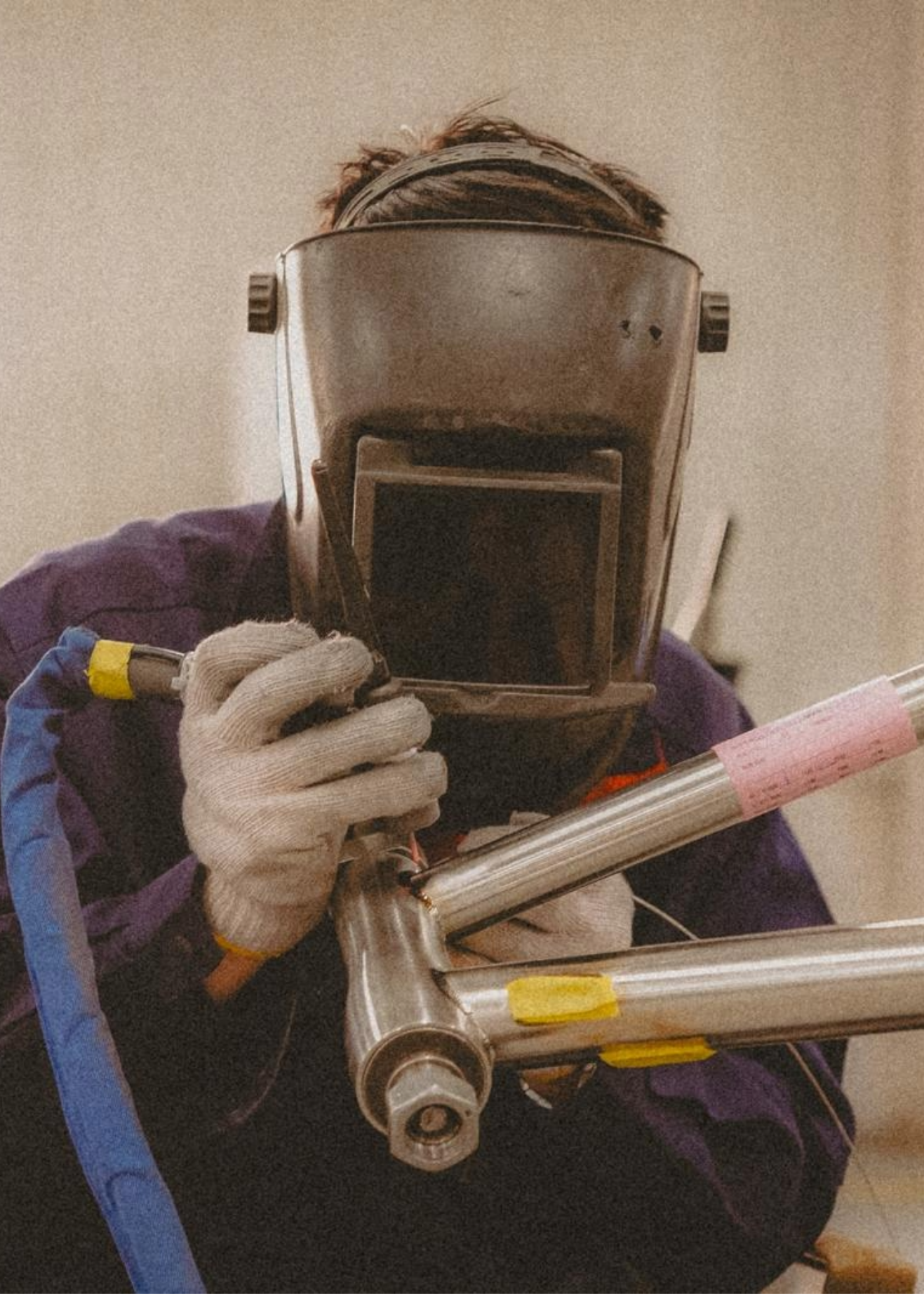 Person welding a metal object with a protective mask on.